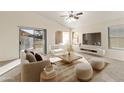 Sunlit living room boasts a sliding glass door, neutral furnishings, and a stylish grid pattern coffee table at 17867 W Eugene Ter, Surprise, AZ 85388