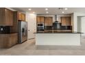 Modern kitchen with wood cabinets, stainless steel appliances, and an island at 7124 W Gambit Trl, Peoria, AZ 85383