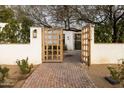 Open wood gate leading to a courtyard entry at 12801 N 65Th Pl, Scottsdale, AZ 85254