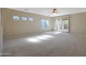 Spacious, carpeted living room with bright, natural light and a ceiling fan at 27174 N 85Th Dr, Peoria, AZ 85383