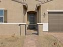 Close-up view of a charming front entrance with a secure gated entryway and brick walkway at 17672 W Pierson St, Goodyear, AZ 85395