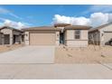 Tan one-story house with a two-car garage and desert landscaping at 18350 W Poston Dr, Surprise, AZ 85387