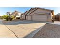 Tan three-car garage home with driveway and desert landscaping at 43205 W Askew Dr, Maricopa, AZ 85138