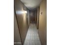 A long hallway with tiled floors and light fixtures at 2310 N 40Th Dr, Phoenix, AZ 85009