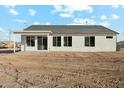 A rear view of a single story house with large sliding glass doors leading to the yard at 13634 S 192Nd Ave, Buckeye, AZ 85326