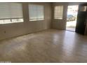 View of living room, showing neutral walls, wood-look floors, and natural light from front windows and door at 141 N Pasadena --, Mesa, AZ 85201