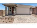 Charming single-Gathering home featuring a front door, two-car garage, and a well-maintained, professionally-designed paver driveway at 5649 N 205Th Ln, Buckeye, AZ 85396