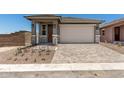 Charming single-Gathering home featuring a front door, two-car garage, and a well-maintained, professionally-designed paver driveway at 5649 N 205Th Ln, Buckeye, AZ 85396