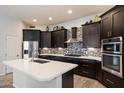 Beautiful kitchen featuring dark cabinets, stainless steel appliances, and stylish backsplash at 7979 E Princess Dr # 13, Scottsdale, AZ 85255