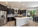 Modern kitchen with stainless steel appliances, dark wood cabinets, and a center island at 7979 E Princess Dr # 13, Scottsdale, AZ 85255