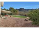 Relaxing backyard oasis with a covered patio, mountain views, and gravel at 2343 E Orangewood Ave, Phoenix, AZ 85020