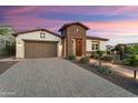 Charming home with desert landscaping, stone accents, and a tiled roof with a brick-paver driveway at 4779 N 205Th Gln, Buckeye, AZ 85396