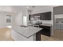 Kitchen featuring stainless steel appliances, dark wood cabinets, and center island with double sink at 36375 W Picasso St, Maricopa, AZ 85138