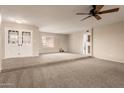 Spacious living room with carpeting, double doors and a ceiling fan at 5022 E Magic Stone Dr, Phoenix, AZ 85044