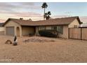 Charming home with a neutral facade, attached garage, desert landscaping, and towering palm trees at 5625 W Grovers Ave, Glendale, AZ 85308