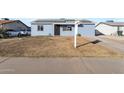 Ranch style home with solar panels and a small front yard at 6842 W Holly St, Phoenix, AZ 85035