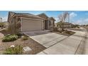 Charming single-story home with a two-car garage, stone accents, and desert landscaping at 26783 W Zachary Dr, Buckeye, AZ 85396