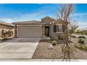 Charming single-story home with a two-car garage, stone accents, and desert landscaping at 26783 W Zachary Dr, Buckeye, AZ 85396