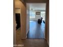 Hallway view showcasing the wood flooring leading into a naturally lit living room with a view at 26783 W Zachary Dr, Buckeye, AZ 85396