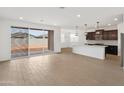 Bright and airy living room with sliding glass doors, modern light fixtures, and an open concept layout at 36834 W La Paz St, Maricopa, AZ 85138