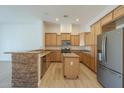 Modern kitchen featuring wooden cabinetry, stone counter, and stainless steel appliances at 3948 W Salter Dr, Glendale, AZ 85308