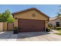 House exterior with a brown garage door and manicured landscaping at 16209 W Davis Rd, Surprise, AZ 85374