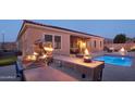 Outdoor kitchen, pool, and patio with fire features at 12866 S 183Rd Ave, Goodyear, AZ 85338