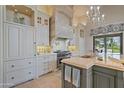 Bright kitchen features custom cabinets, a professional range, a large island, and elegant lighting fixtures at 6322 E Turquoise Ave, Paradise Valley, AZ 85253