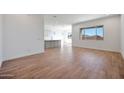Bright living room featuring wood-look tile floors, white walls, and a view into the modern kitchen at 28233 N 134Th Ave Ave, Peoria, AZ 85383