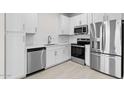 An all-white kitchen with stainless steel appliances and modern finishes at 7504 S 75Th Dr, Laveen, AZ 85339