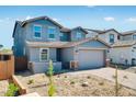 Two-story home featuring blue facade, gabled roof, with a brick driveway leading to an attached two-car garage at 8975 S 168Th Ln, Goodyear, AZ 85338