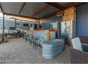 Spacious outdoor covered bar area with a refrigerator and nearby camper at 10120 E Mclellan Rd, Mesa, AZ 85207