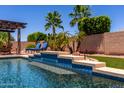 Gorgeous backyard pool with a tanning ledge and comfortable lounge chairs for soaking up the sun at 18174 W Wind Song Ave, Goodyear, AZ 85338