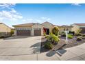 Front view of a single-story home with a two-car garage and well-manicured landscaping at 20103 N 265Th Ave, Buckeye, AZ 85396