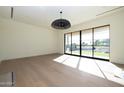Open living space featuring hardwood floors, modern lighting, and large windows with backyard views at 23002 N Country Club Trl Trl, Scottsdale, AZ 85255