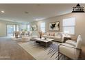 Bright and spacious living room with adjacent dining area, staged with modern furniture at 9098 S 256Th Ln, Buckeye, AZ 85326