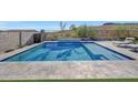 Inviting rectangular pool with a tiled deck and lounge chairs at 13487 W Roy Rogers Rd, Peoria, AZ 85383