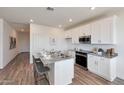 Modern kitchen with white cabinets, granite countertops, and island at 18116 W Cielo Grande Ave, Surprise, AZ 85387