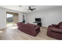 Living room with tile floors, a ceiling fan, and sliding glass doors at 35907 W San Clemente Ave, Maricopa, AZ 85138