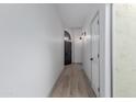 Bright hallway with wood-look tile flooring, contemporary lighting, and arched doorway at 7955 E Chaparral Rd # 103, Scottsdale, AZ 85250