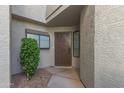 Front entry with a brown metal door and small landscaped area at 1108 W Mango Dr, Gilbert, AZ 85233