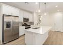 Modern kitchen featuring stainless steel appliances, white cabinetry, and a center island with sink at 2848 N Evergreen St, Buckeye, AZ 85396