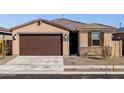 Charming single-story home with a two-car garage, stone accents and low maintenance desert landscaping at 16032 W Desert Hollow Dr, Surprise, AZ 85387