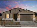 Inviting exterior view of a single-story home featuring neutral colors and a two-car garage at 16072 W Prickly Pear Trl, Surprise, AZ 85387