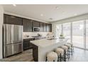 Modern kitchen with stainless steel appliances, quartz counters, and a large island with bar seating at 3247 W Garnet St, San Tan Valley, AZ 85144