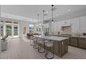 Modern kitchen with a large island, stainless steel appliances, and an adjacent dining area at 32994 N 131St Dr, Peoria, AZ 85383