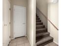 Hallway with carpeted stairs, white door, light tan walls, and tile floor at 1335 E June St # 239, Mesa, AZ 85203