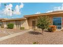 Tan single story home with landscaped yard and walkway at 13428 N Hawthorn Dr, Sun City, AZ 85351
