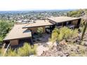 Modern home with a flat roof, desert landscaping, and views of the city in the distance at 4060 E Lamar Rd, Paradise Valley, AZ 85253