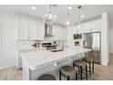 Modern white kitchen with island, stainless steel appliances, and quartz countertops at 634 E Deer Creek Rd, Phoenix, AZ 85048